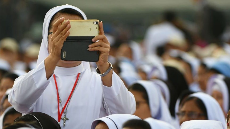 Častna sestra fotografiše mobilnim telefonom