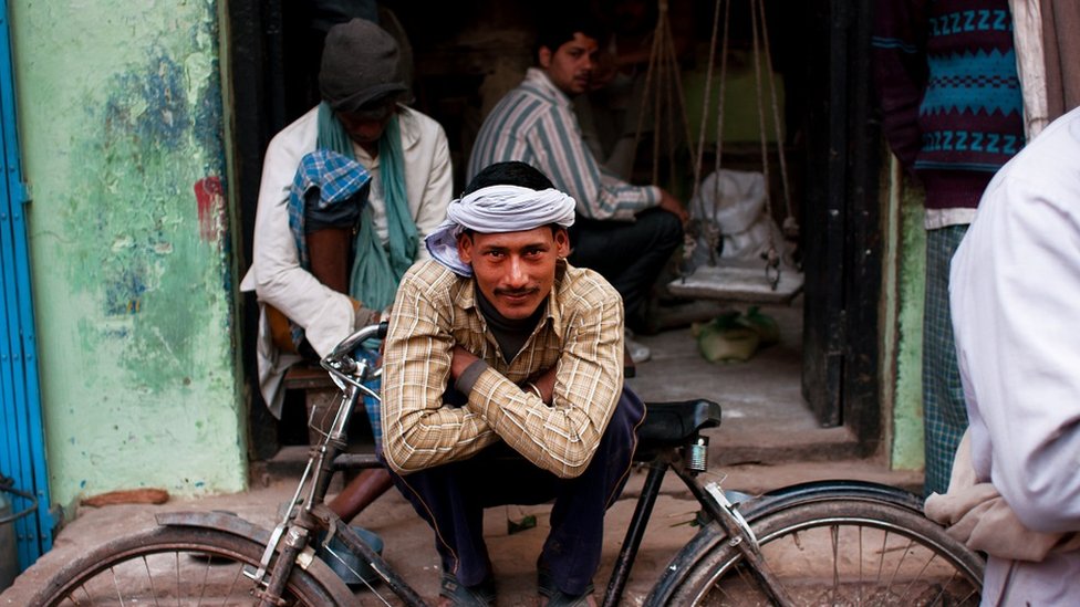 A young man sitting outside a workshop