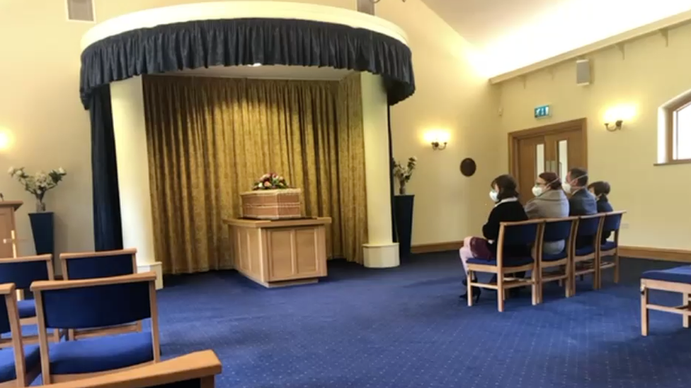 View of my mum's coffin and my family wearing masks