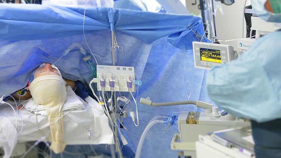 A man lying on a bed during surgery