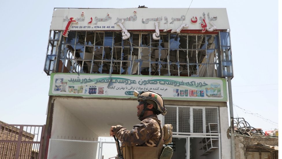 An Afghan soldier patrols in front of a bombed out building in Kabul