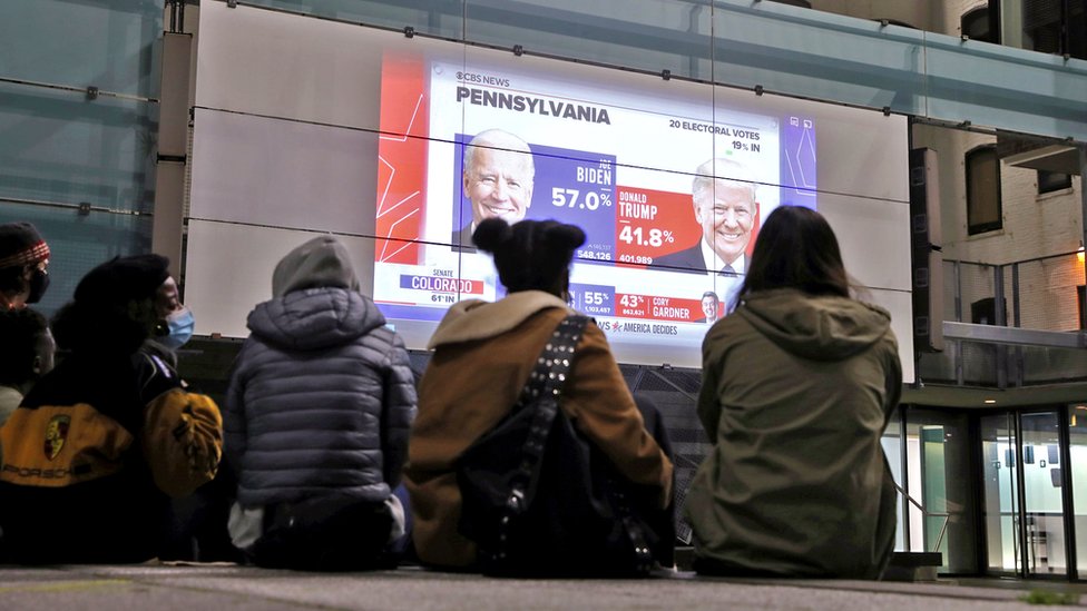 ReutersPeople watch early results on a large outdoor screen