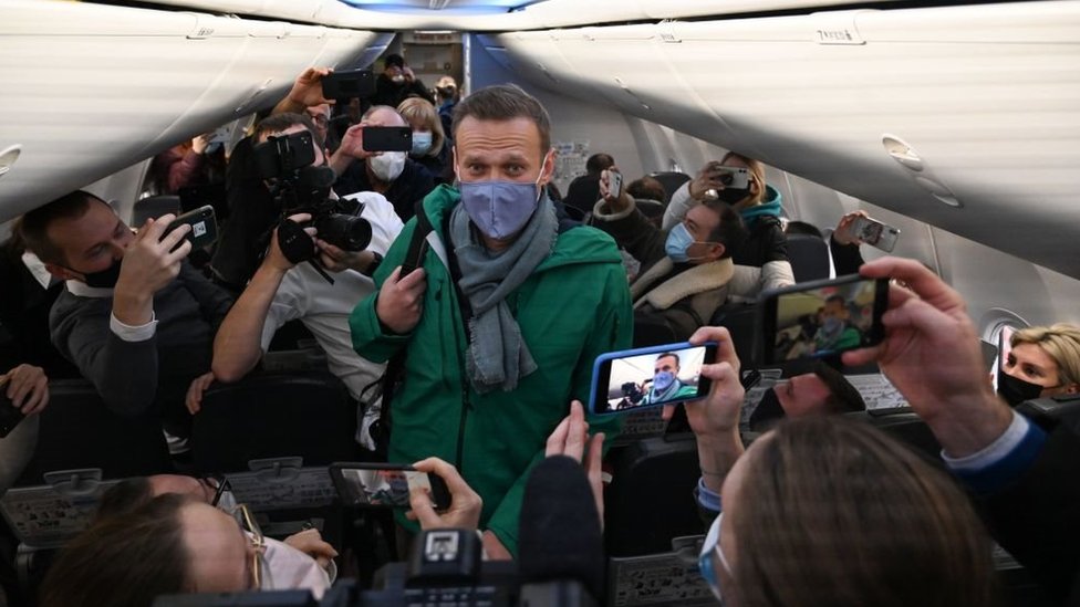 Russian opposition leader Alexei Navalny walks to take his seat in a Pobeda airlines plane heading to Moscow before take-off from Berlin Brandenburg Airport (BER) in Schoenefeld, southeast of Berlin, on January 17, 2021.