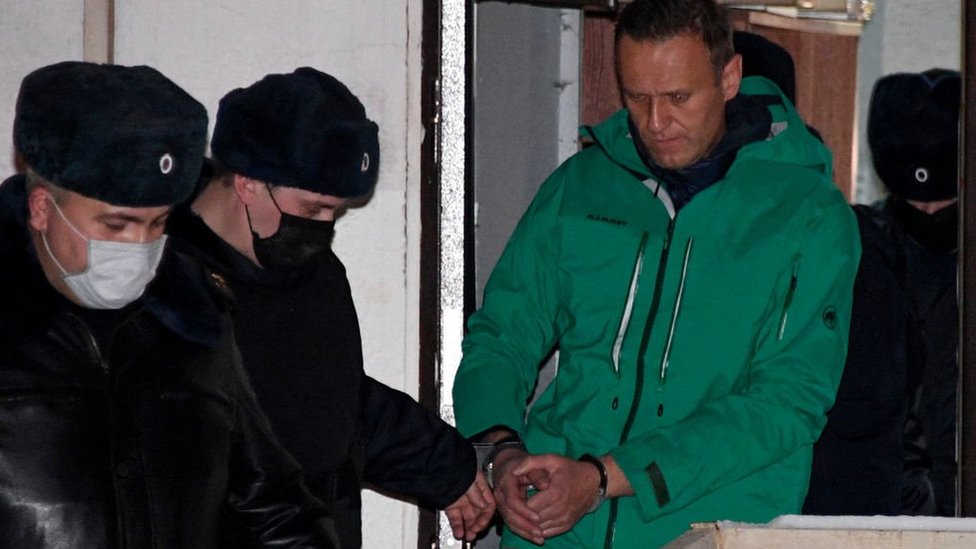 Opposition leader Alexei Navalny is escorted out of a police station on January 18, 2021, in Khimki, outside Moscow