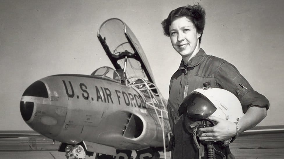 Undated black and white image shows Wally Funk next to US air force aircraft