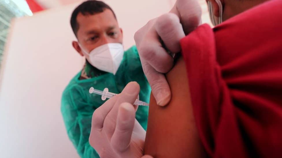 An Indonesian military doctor injects a dose of Sinovac COVID-19 vaccine made by Biofarma to a man during a COVID-19 vaccination drive at Gelora Bung Karno Stadium in Jakarta, Indonesia, 26 June 2021