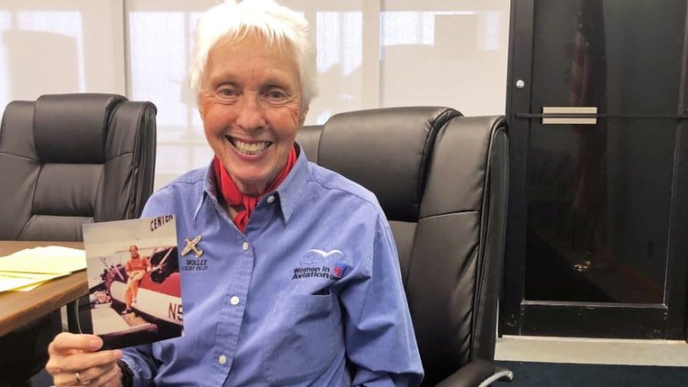 Wally funk holding a photo of herself