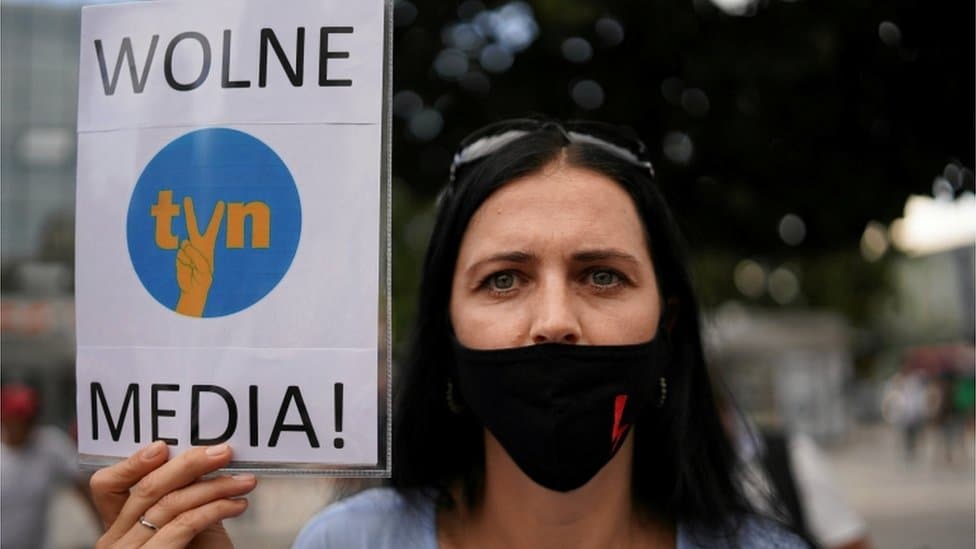 A protester holds a placard reading "Free media!" during a demonstration in Poland