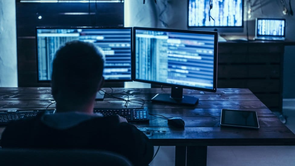 Man in front of various computer screens