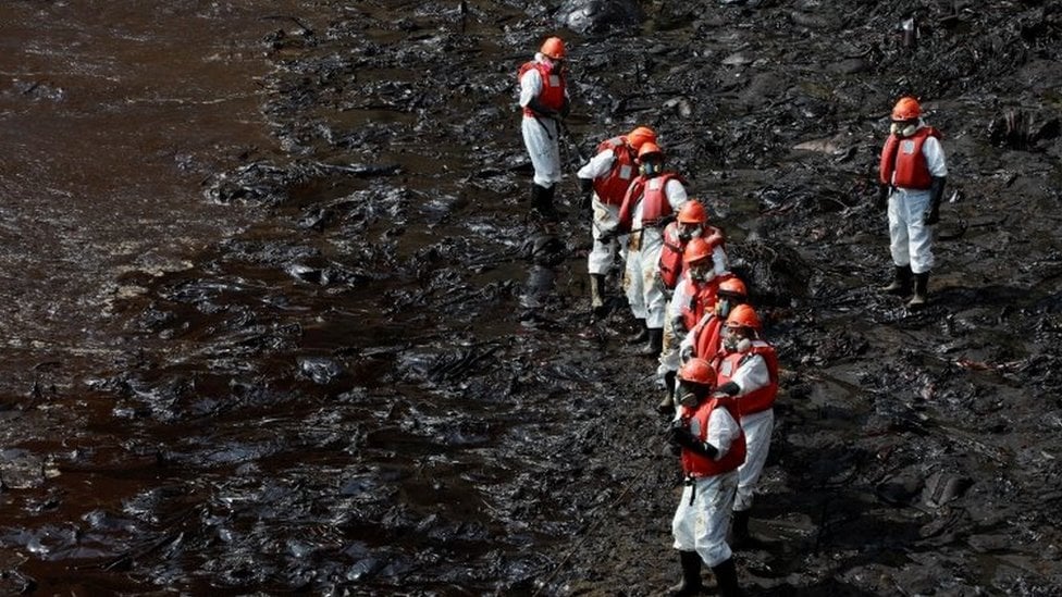 Workers carry out a cleaning operation on the beaches of Ventanilla, Peru, 25 January 2022