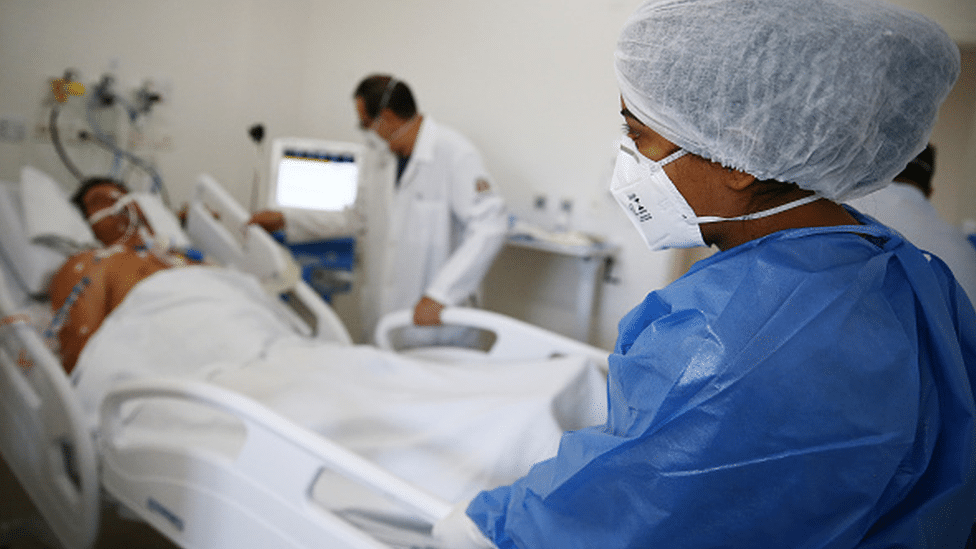 A patient connected to a respiratory device on a hospital bed