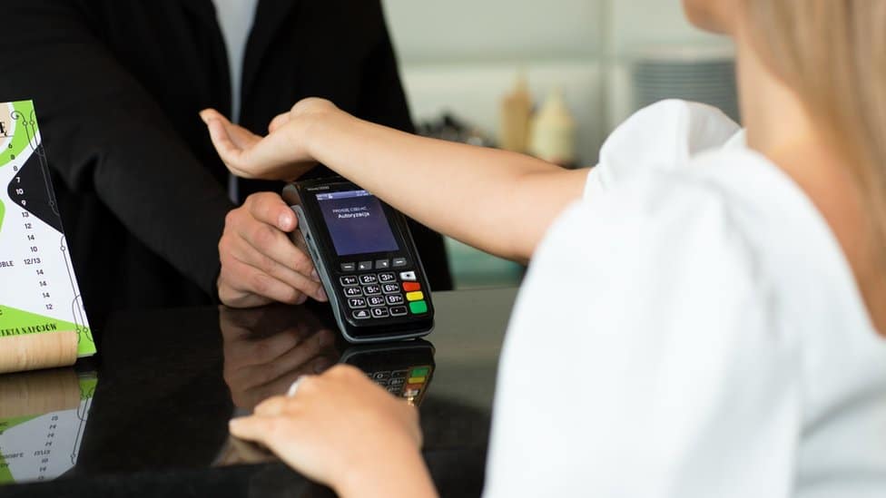 A woman using a contactless payment microchip implant