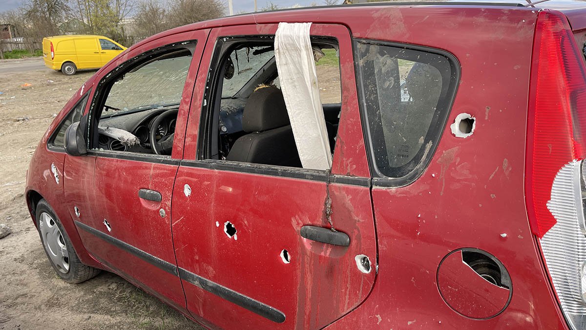 Car with white ribbon and bullet holes