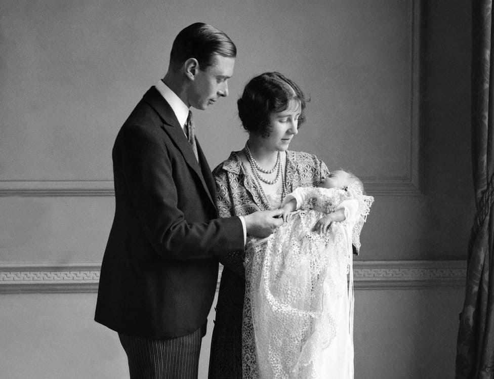 The Queen Mother (then the Duchess of York) with her husband, King George VI (then the Duke of York), and their daughter Queen Elizabeth II (then Elizabeth Alexandra Mary Windsor) at her christening in May 1926