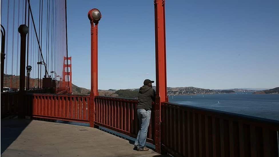 A man looks at the view from the Golden Gate Bridge