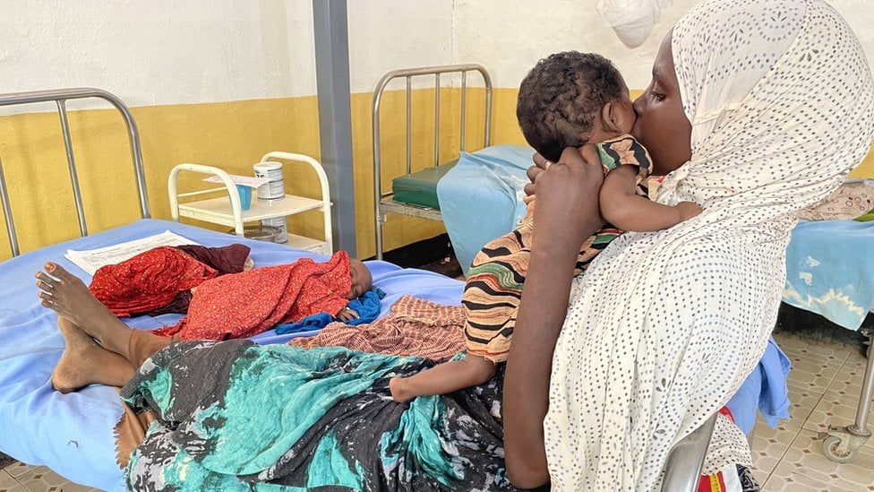 Hawa holding her two-mon-old daughter Ubah and Abdiwali lying on the bed, the day before he died