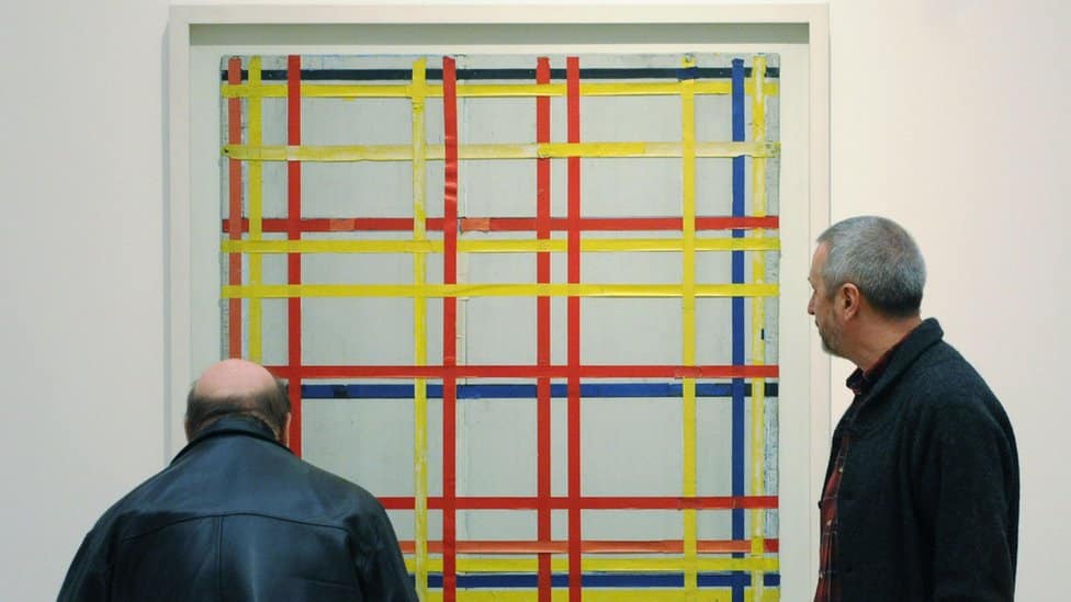 Two men looking at Mondrian's New York City I