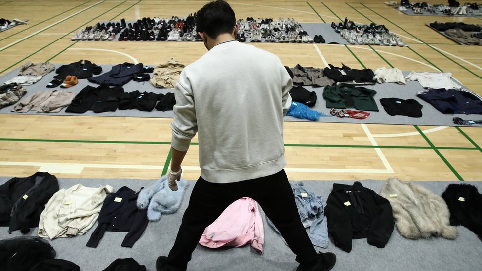 Man looking through abandoned belongings in Seoul Gym.