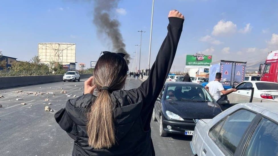 A woman without a headscarf holds up her arm during a protest in the Iranian city of Karaj on 3 November 2022