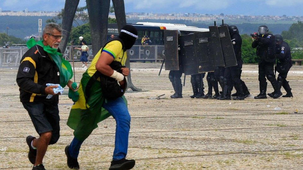 Security forces confront supporters of Brazilian former President Jair Bolsonaro as they invade Planalto Presidential Palace in Brasilia on January 8, 2023