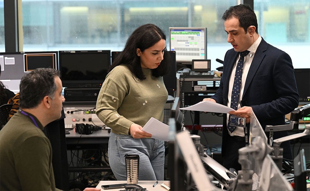 Parham Ghobadi (R) chats with BBC Persian staff in the office