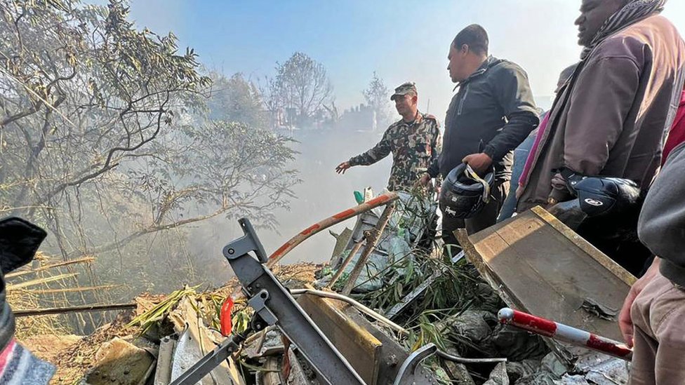 Rescuers gather at the site of a plane crash in Pokhara