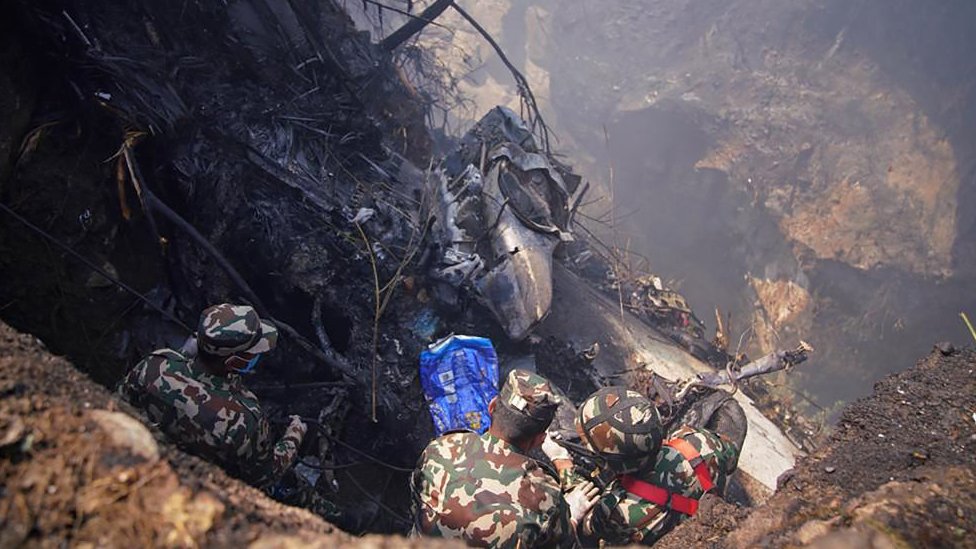 Rescuers inspect the site of a plane crash in Pokhara