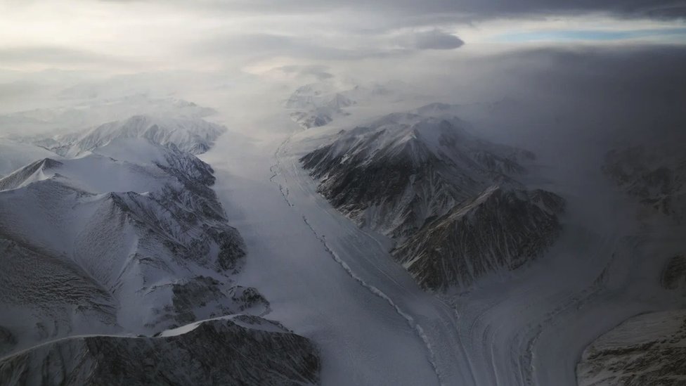 Snow-covered mountains with a deep valley with a layer of snow