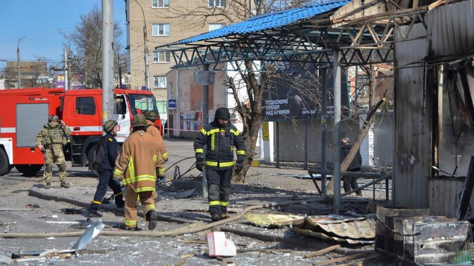 Rescuers work at a bus stop which was hit during a rocket attack in Kherson