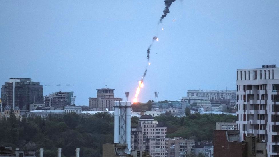 An explosion of a drone is seen in the sky over the city