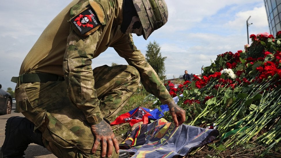 A fighter of Wagner private mercenary group visits a makeshift memorial near former PMC Wagner Centre