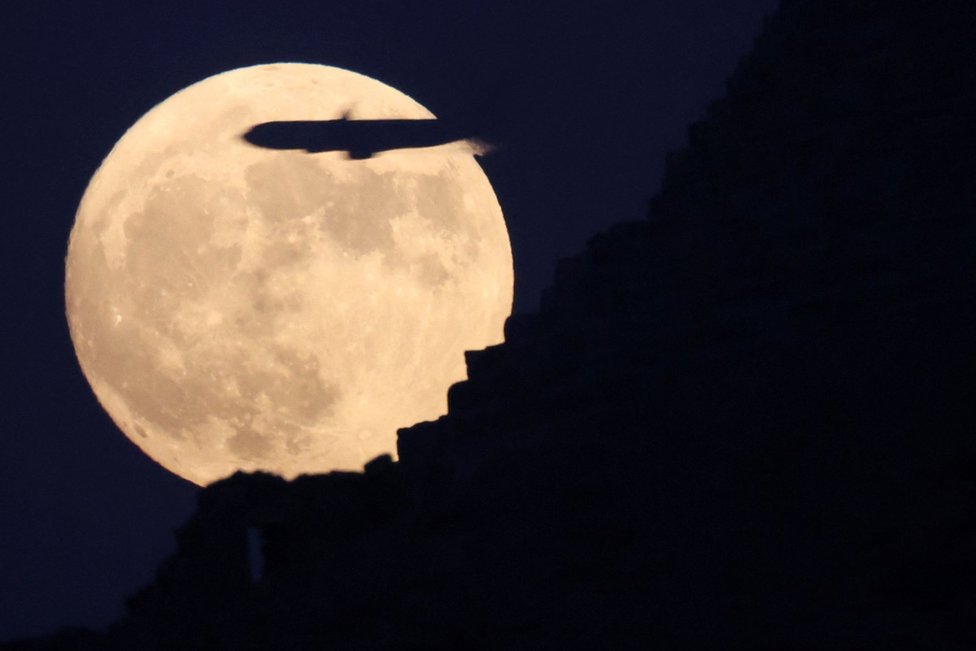 A plane flies by the blue supermoon rising above the Pyramids of Giza in Egypt. Photo: 30 August 2023