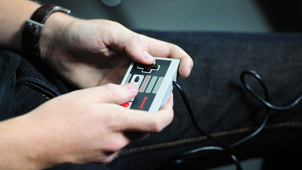 Person holding a NES controller.