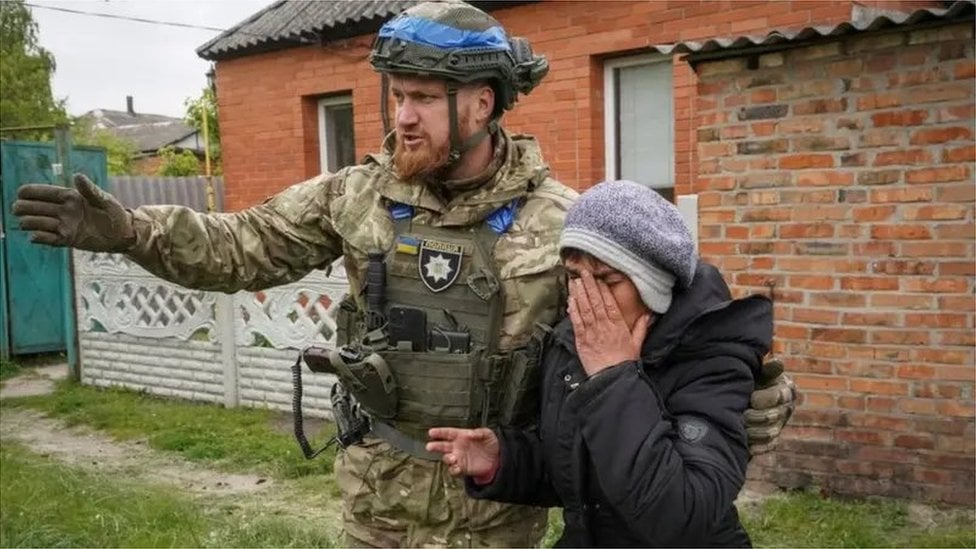 Ukrajinski vojnik pomaže u evakuaciji stanovništva u okolini Volčanska