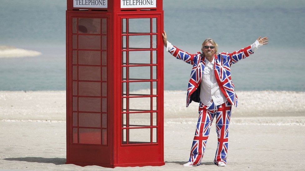 Sir Richard Branson on one of the islands in The World Dubai, with a red telephone box