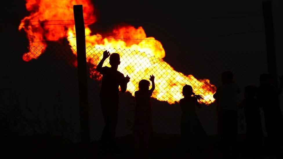 Child at fence line with flare behind