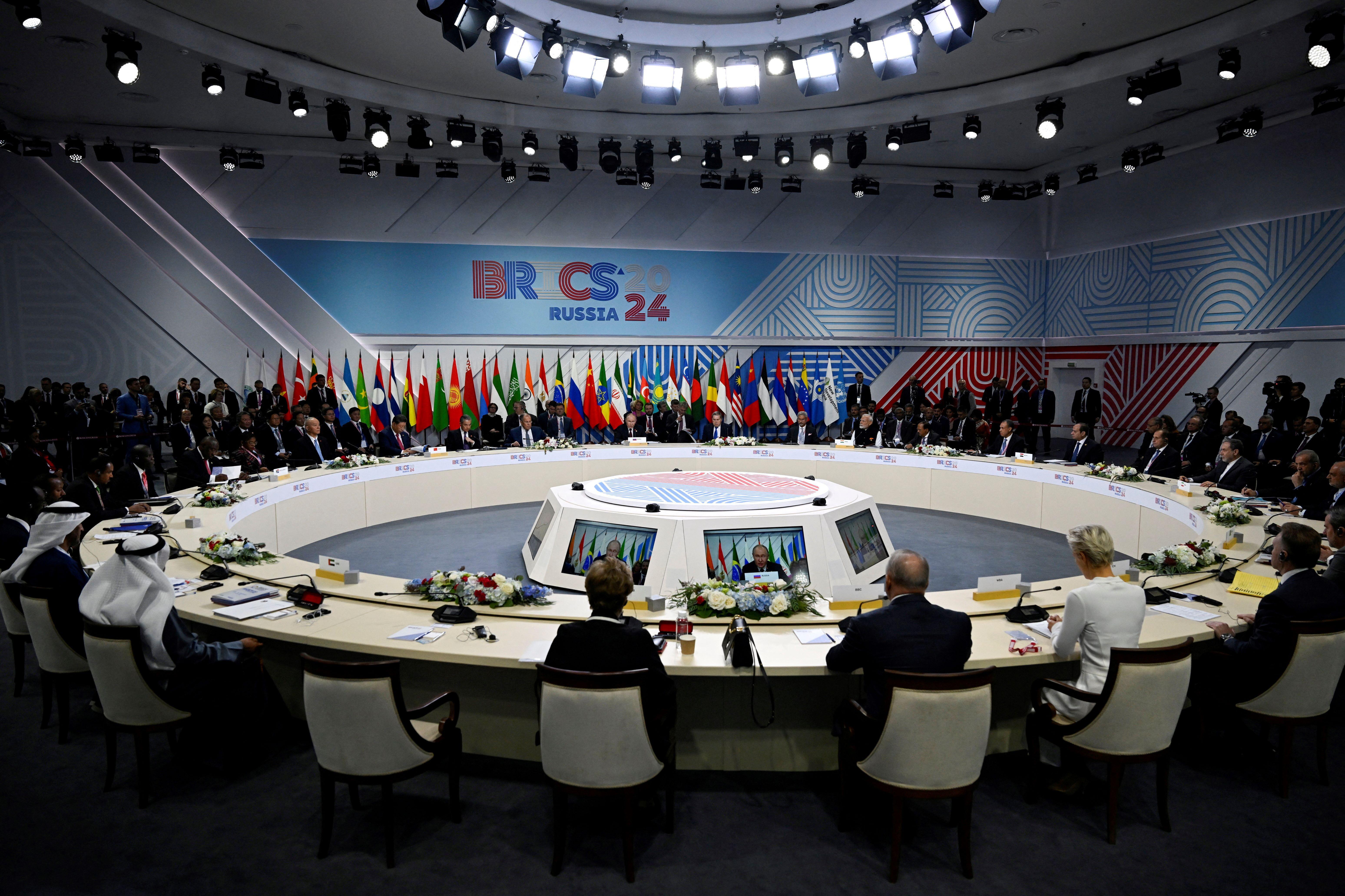 Representatives of countries at the Brics summit sit at a round table during Vladimir Putin's opening speech