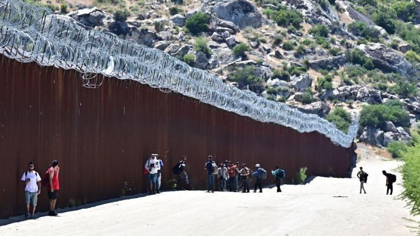 Migranti pokušavaju da pređu zid između SAD i Meksika