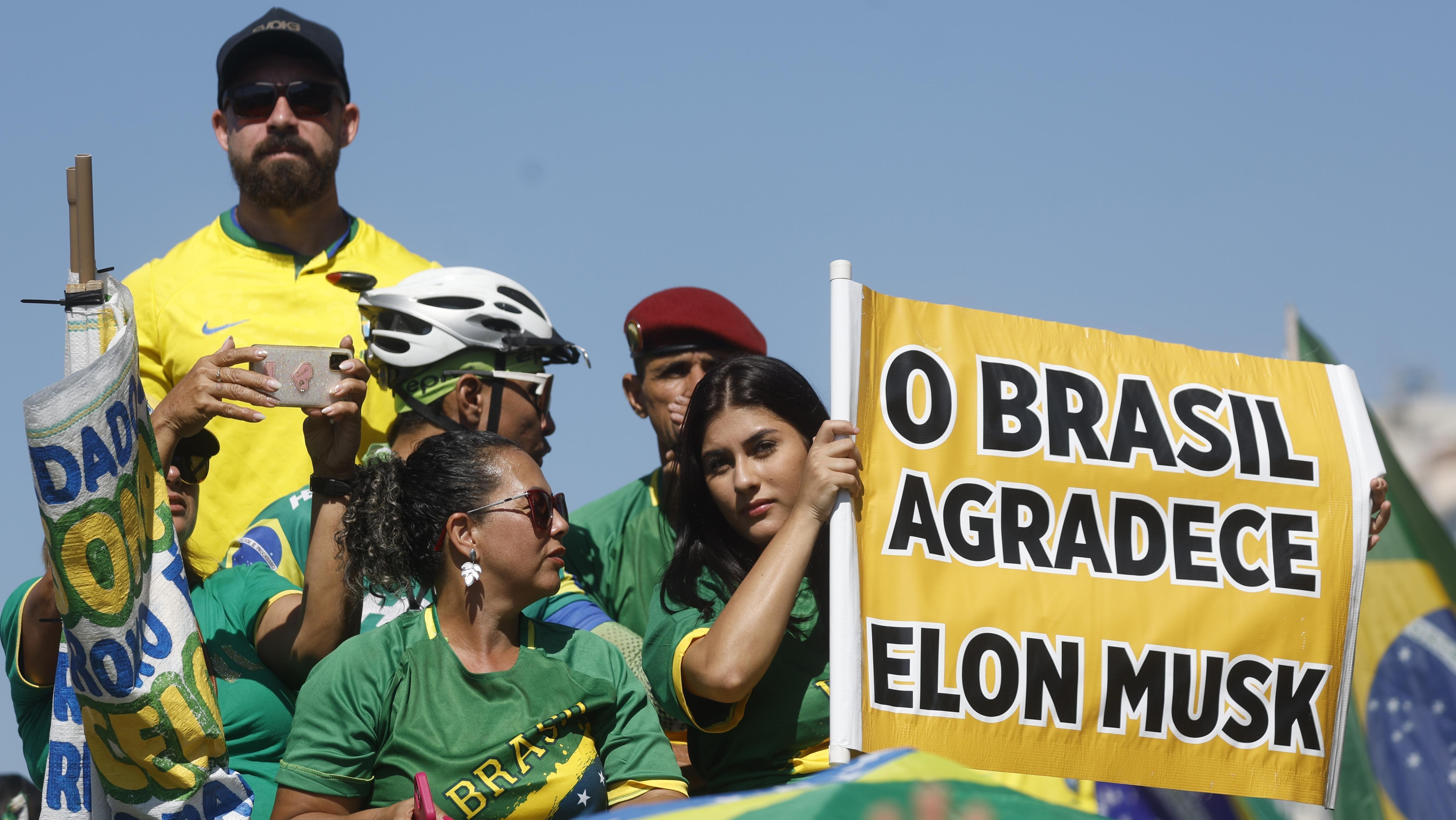 Grupa ljudi u Brazilu drži znak zahvalnosti Masku