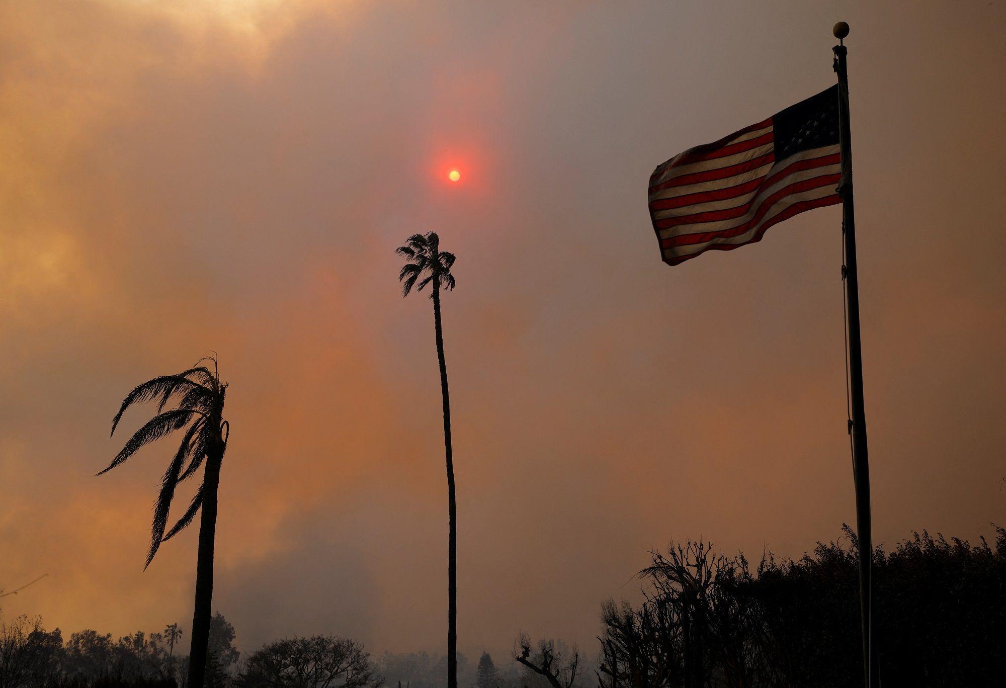 Crni gusti dim i dve spaljene palme pored američke zastave