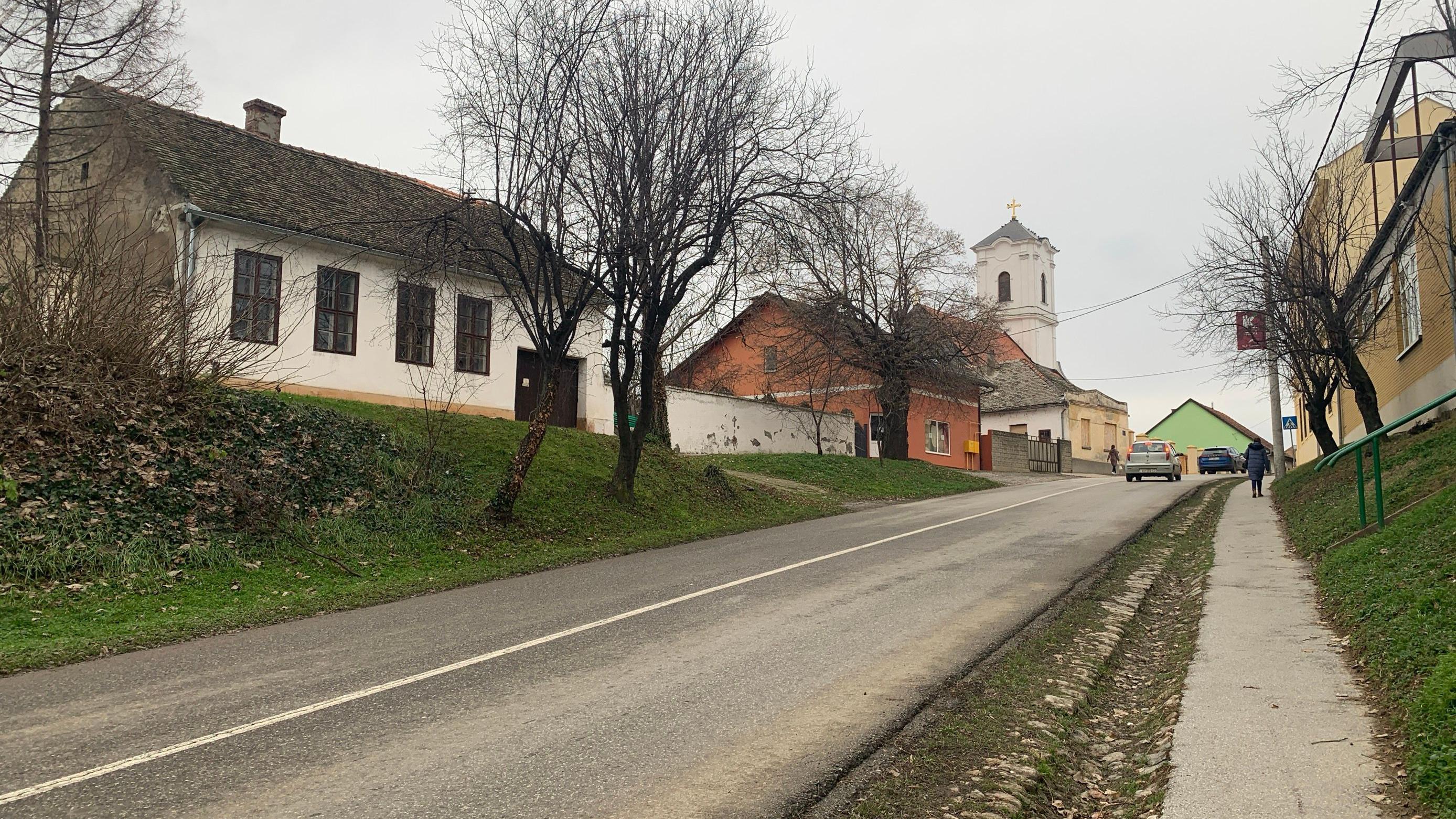 Ulica, prazne kuće i crkva u centru Iloka